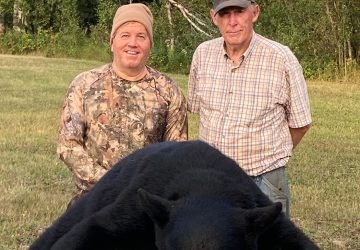 Two Men Smiling With Hunted Black Bear